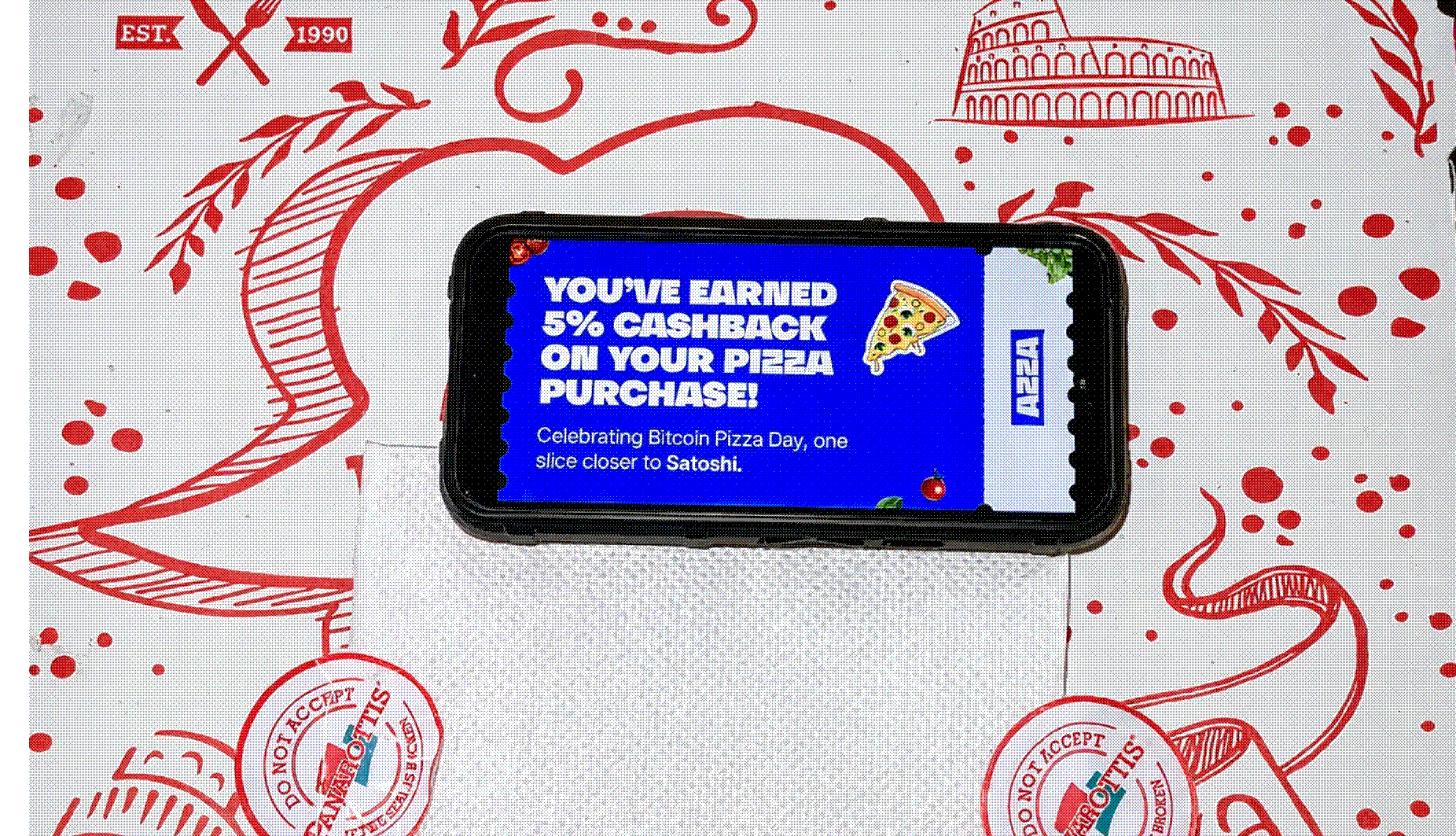 Phone displaying an Azza cashback coupon on a pizza-themed tablecloth background